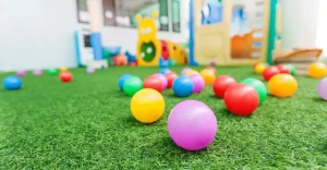 Colorful balls scattered on green artificial grass in a play area