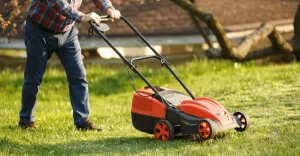 Person pushing a lawn mower over grass