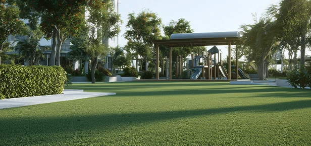 Playground structure in a grassy area surrounded by trees and bushes